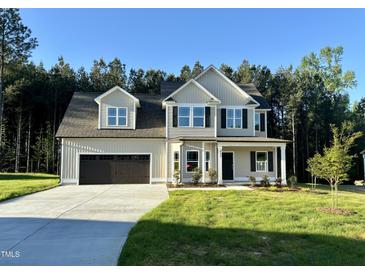 Charming two-story home with a two-car garage and landscaped yard with a treeline at 437 Earnest Way, Kenly, NC 27542