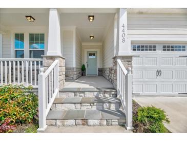 Charming front porch features stone accents, white railings, and a light blue front door at 4408 Walker Hallow St, Raleigh, NC 27616