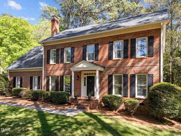 Charming brick home featuring a classic colonial design with black shutters and a manicured lawn at 4533 Wood Valley Dr, Raleigh, NC 27613