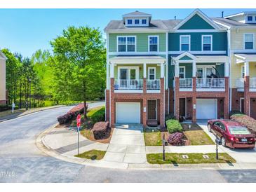 Charming townhome with a brick front, balcony, and attached garage on a cul-de-sac street at 705 Samuel Cary Dr, Cary, NC 27511