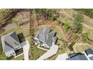 Stunning aerial view of home nestled on a lush lot with mature trees and impeccable landscaping at 8208 Bella Oak Ct, Wake Forest, NC 27587