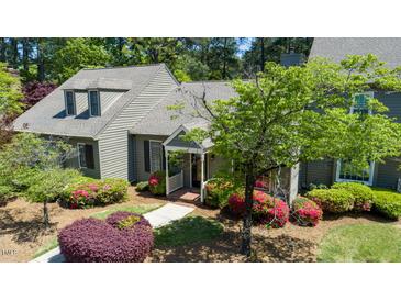 Charming home with beautiful landscaping featuring mature trees and colorful flowering bushes enhancing curb appeal at 918 Albany Ct, Raleigh, NC 27615