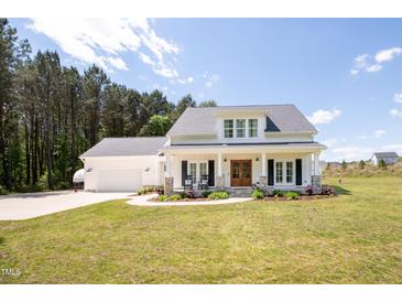Beautiful two-story white home with a manicured lawn and inviting front porch at 9947 Nc Hwy 96 N, Selma, NC 27576