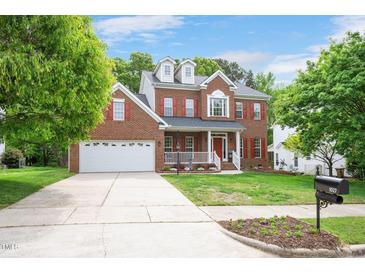Charming two-story brick home with red shutters, landscaped lawn and a two-car garage at 1027 Upchurch Farm Ln, Cary, NC 27519