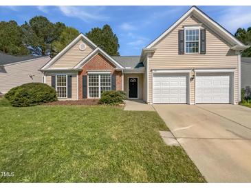 Charming single Gathering home featuring a two car garage, manicured lawn and brick accents at 107 Kinship Ln, Apex, NC 27502