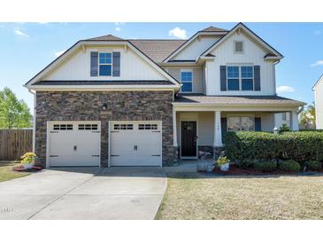 Charming two-story home featuring a two-car garage, stone accents, and manicured landscaping at 138 Horizon Trl, Garner, NC 27529