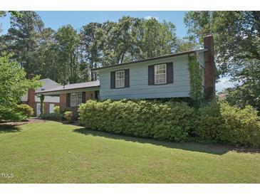 Charming two-story home featuring a brick and siding exterior, lush landscaping, and a well-maintained lawn at 1636 Cone Ave, Apex, NC 27502