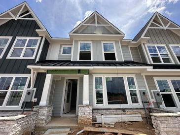 Charming new construction home with stone accents, gray siding, and a welcoming front entrance at 3022 White Rail Dr, Fuquay Varina, NC 27526