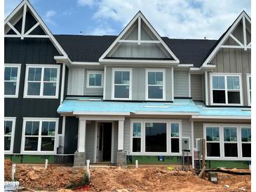 A modern two-story townhouse under construction with gray siding, black roof, and white trim, showcasing contemporary design at 3022 White Rail Dr, Fuquay Varina, NC 27526
