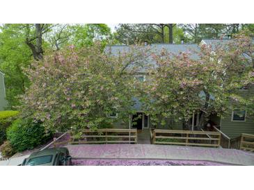 Charming exterior view with flowering trees and wood fence at 304 Cedarwood Ln, Carrboro, NC 27510