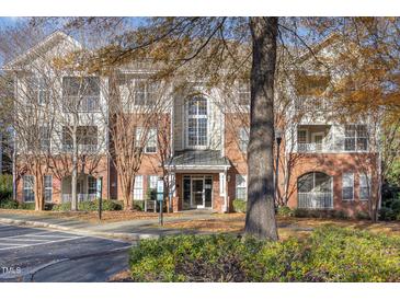 Brick condo building featuring balconies, multiple windows, and well-maintained landscaping at 311 Providence Glen Dr, Chapel Hill, NC 27514