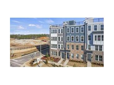 New townhome community with a contemporary design showcasing multi-story facades, and a rooftop terrace at 404 Gaston Park Ln # 100, Wake Forest, NC 27587