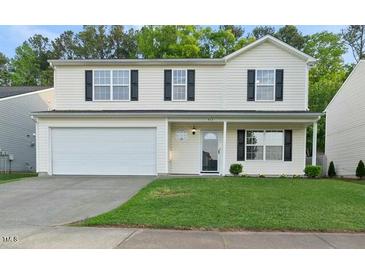 Charming two-story home with a well-maintained lawn and attached two-car garage at 413 Weeping Willow Dr, Durham, NC 27704