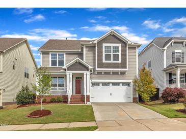 Charming two-story home with a well-manicured lawn, attached garage, and a welcoming front porch at 4252 Rockdell Hall St, Raleigh, NC 27616