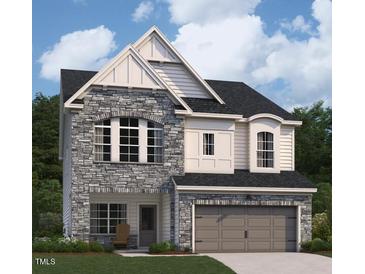 Charming two-story home showcasing a stone facade, arched windows, and a two-car garage at 4311 Emeline Way # 13, Fuquay Varina, NC 27526