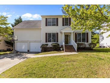 Inviting two-story home featuring a well-manicured lawn, a two-car garage, and a charming front entrance with classic design at 707 Southshore Pkwy, Durham, NC 27703