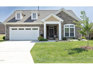 Charming single-Gathering home featuring a stone facade, dormer windows, and a well-manicured lawn at 769 Ashley Woods Dr, Gibsonville, NC 27249