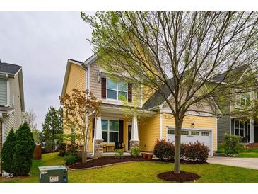 Charming two-story home with yellow siding, a covered front porch, and well-maintained landscaping at 91 Cliffdale Rd, Chapel Hill, NC 27516