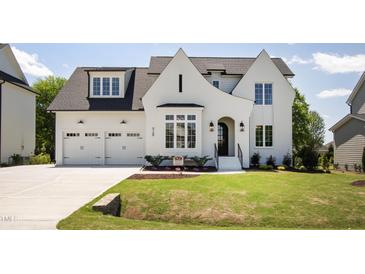 Beautiful two-story home with a well-manicured lawn, attached two car garage, and classic black and white trim at 928 Lily Claire Ln, Fuquay Varina, NC 27526