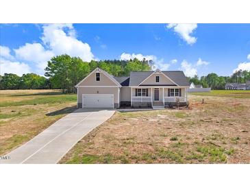 Charming single-Gathering home boasts a manicured lawn and attached two-car garage at 9391 Turkey Way, Middlesex, NC 27557
