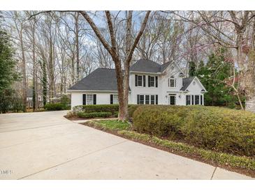 Beautiful white home featuring black shutters, dark roof, and a circular driveway at 108 Monarch Way, Cary, NC 27518
