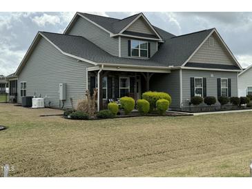 Charming two-story home with gray siding, covered porch, and manicured front lawn at 116 Polenta Fields Dr, Smithfield, NC 27577