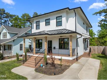 Charming two-story home featuring a covered front porch with brick stairs and black railing at 1312 Lancaster St, Durham, NC 27701