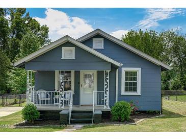 Charming blue home featuring a cozy front porch, white trim, and well-maintained landscaping at 1542 Albright Ave, Burlington, NC 27215