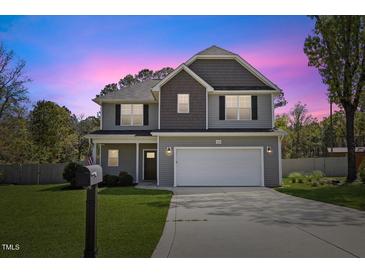 Charming two-story home with a well-manicured lawn and a two-car garage at 166 Old Field Loop Loop, Sanford, NC 27332