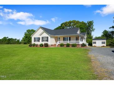 Charming single Gathering home with a well manicured lawn and lovely covered porch and a storage shed at 175 Bill Avery Rd, Coats, NC 27521