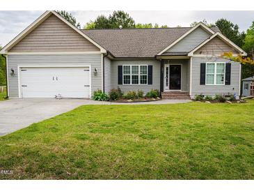 Charming single-Gathering home featuring a well-maintained lawn, an attached garage, and lovely landscaping at 201 Lexington Park Dr, Oxford, NC 27565