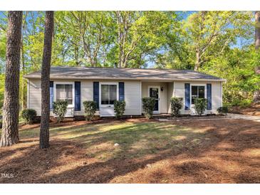 Charming single-story home with blue shutters surrounded by lush greenery and mature trees at 3116 Henslowe Dr, Raleigh, NC 27603