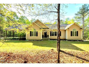 Charming single story home featuring a landscaped lawn, symmetrical windows, and a comfortable covered carport at 452 Dogwood Trl, Henderson, NC 27537