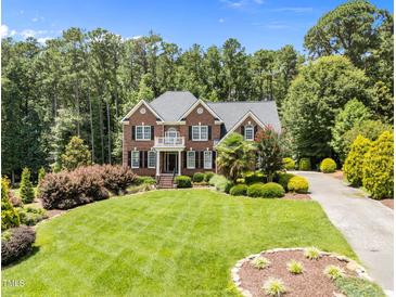 Stately brick home with a manicured lawn and mature trees creating a picturesque setting at 5016 Dillswood Ln, Raleigh, NC 27606