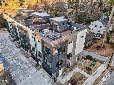 Modern townhome boasts a rooftop deck with outdoor seating and city views at 516 Edgecreek Ct, Raleigh, NC 27604