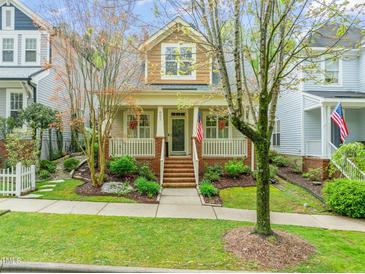 Charming two-story home with a brick porch, landscaped yard, and an American flag waving proudly at 607 Millbrook Dr, Pittsboro, NC 27312