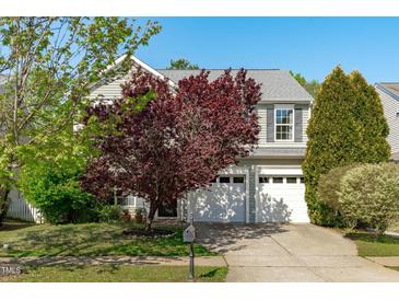 Charming two-story home featuring a well-manicured lawn and a two-car garage at 712 Wellspring Dr, Holly Springs, NC 27540