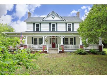 Charming two-story farmhouse with a welcoming porch and beautifully landscaped front yard at 7129 Dexter Rd, Oxford, NC 27565