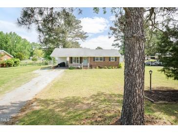 Charming brick home with a well-manicured lawn and a welcoming front porch at 7698 Nc Highway 222, Kenly, NC 27542