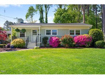 Charming single-story home featuring a well-manicured lawn and mature azaleas, creating a picturesque curb appeal at 806 Edmund St, Raleigh, NC 27604