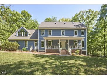 Charming two-story home with a welcoming front porch and lush green lawn at 8407 Millers Bnd, Bahama, NC 27503