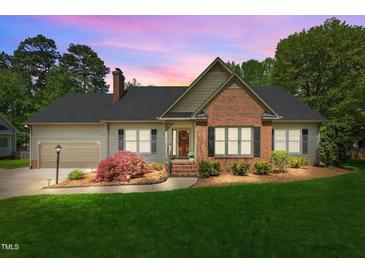 Charming single-story home boasts a manicured lawn, brick accents, and a welcoming front porch at 910 S Third St, Mebane, NC 27302