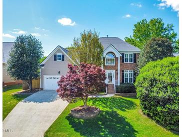 Charming two-story home with brick and siding, manicured lawn, and mature trees at 102 Traviliah Oaks Ln, Cary, NC 27518