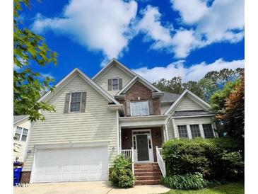 Charming two-story home featuring a symmetrical design, light siding, brick accents, and an attached two-car garage at 105 Dairy Ct, Chapel Hill, NC 27516