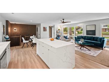 Bright living room boasts a large island, light hardwood floors, and lots of natural light at 1124 Hardimont Rd, Raleigh, NC 27609