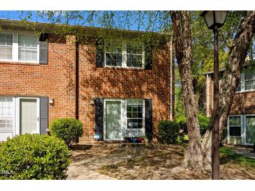 Charming brick townhome with black shutters, well-maintained landscaping, and inviting entrance at 115 Coleridge Ct, Carrboro, NC 27510