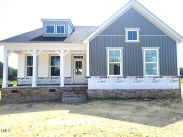 Charming two-story new home with a covered porch and modern gray siding at 152 Cultivator Ct, Angier, NC 27501