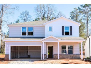 Two-story home features an attached two-car garage, neutral color palette, and craftsman-style front door at 169 Klamath Dr, Garner, NC 27529