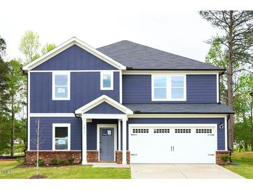Charming two-story home showcasing a well-maintained lawn and a classic architectural design at 3813 Rosebush Dr, Zebulon, NC 27597