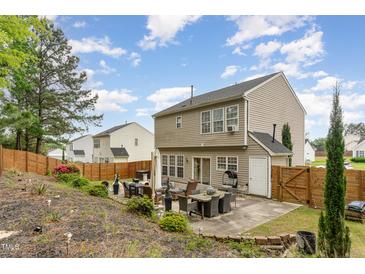 Cozy backyard features a patio with outdoor seating, privacy fence, and a two-story home with neutral siding at 406 Sapphire Dr, Durham, NC 27703